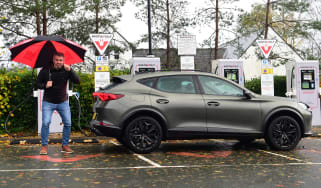 Auto Express deputy editor Richard Ingram standing with the Cupra Formentor in front of an array of Instavolt chargers