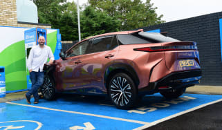 Auto Express creative director Darren Wilson standing with the Lexus RZ in a charging bay